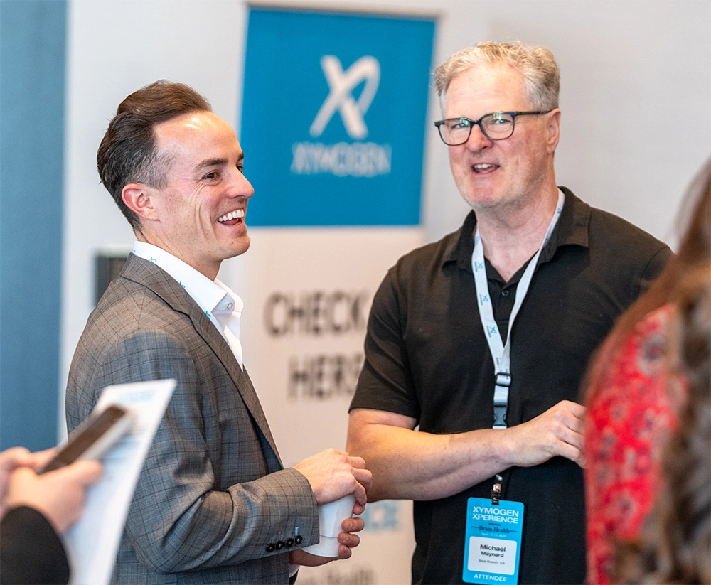 Brian Blackburn Jr., XYMOGEN's Chief Strategy Officer, speaking with conference goers 