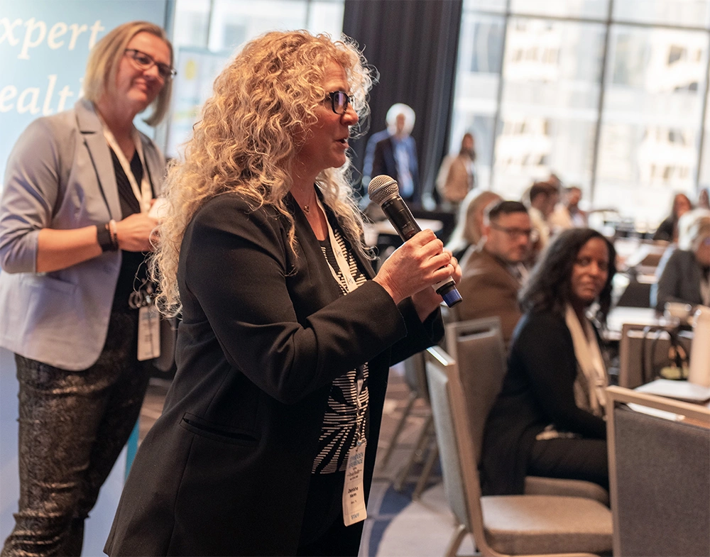 A conference attendee asking a question during a Q&A event